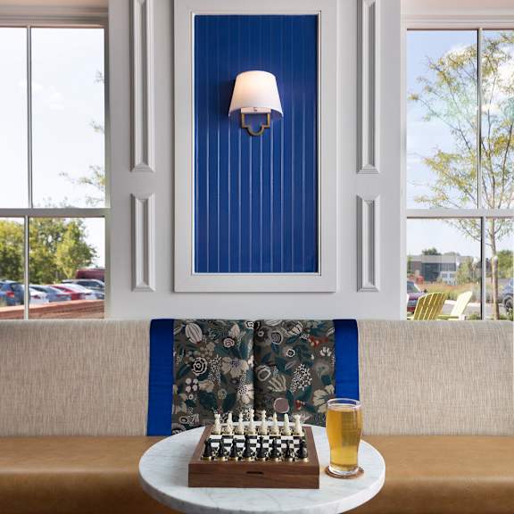a blue and white framed picture with a lit candle on a table.