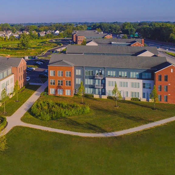 a large building complex with a green lawn in front.