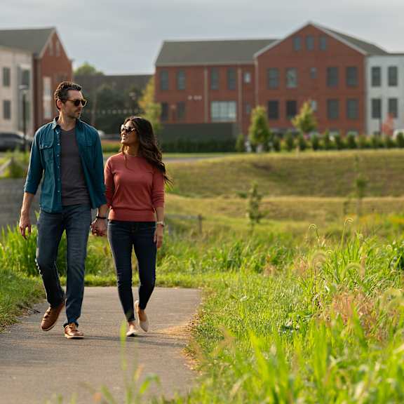 a man and a woman are walking on a path.