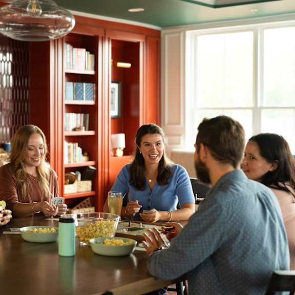 a group of people are sitting around a table eating popcorn.