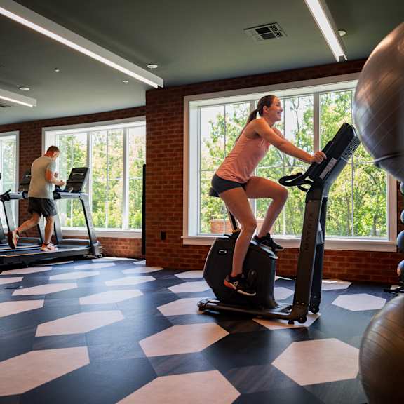 a woman is exercising on a treadmill in a gym.