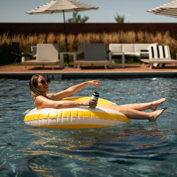 a woman is floating on a yellow float in a pool.