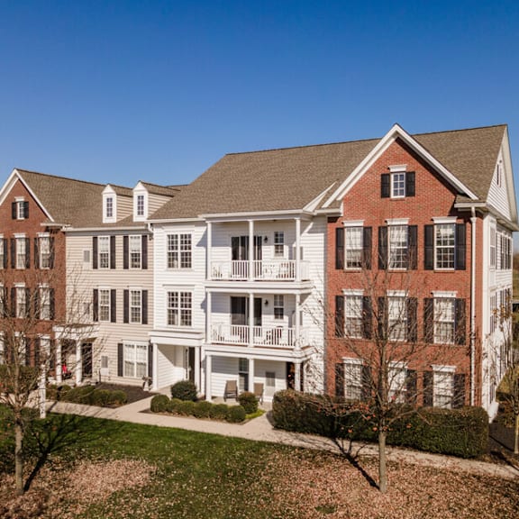 a large red brick house with a white porch.