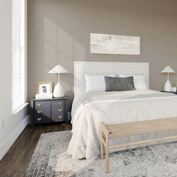 a bedroom with a white bed and a rug