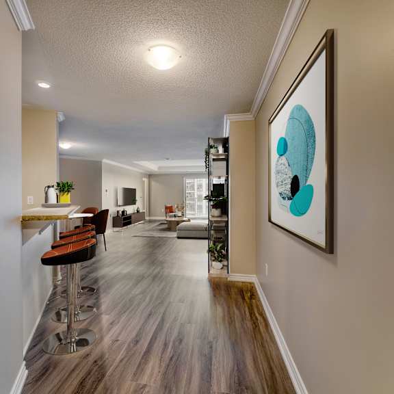 a kitchen and living room with hardwood flooring and a painting on the wall