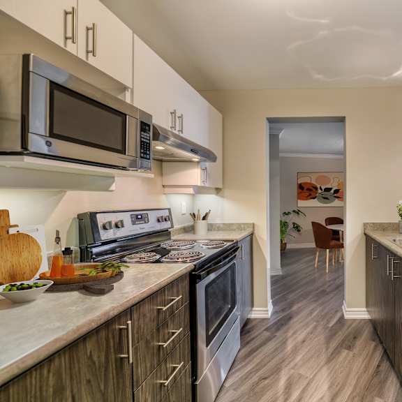 a kitchen with white cabinets and a wooden floor