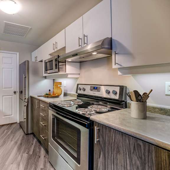 a kitchen with white cabinets and stainless steel appliances