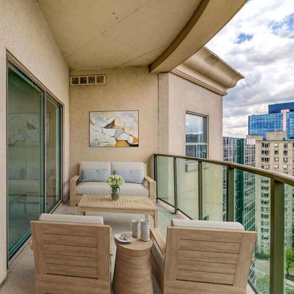 a balcony with a couch a table and two chairs
