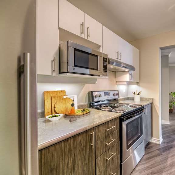 a kitchen with white cabinets and stainless steel appliances