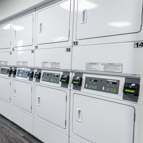 a row of washers and dryers in a utility room