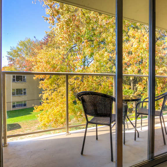 a balcony with a table and two chairs and a large window