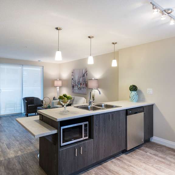 a kitchen with an island and a living room in the background