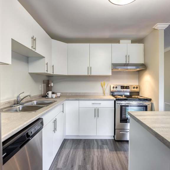 a kitchen with white cabinets and stainless steel appliances