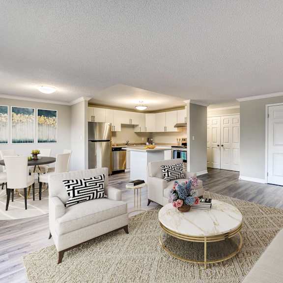a living room with furniture and a kitchen in the background