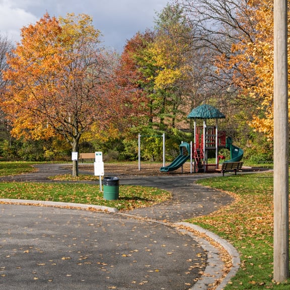 a playground with a green slide and a white sign.