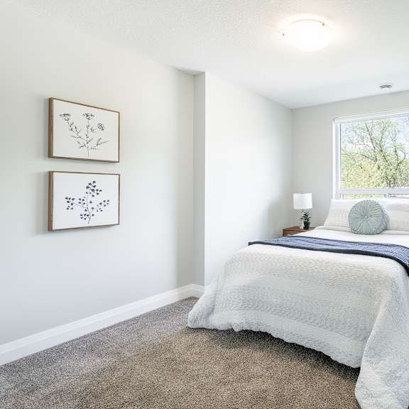 a bedroom with a large bed and two pictures on the wall.