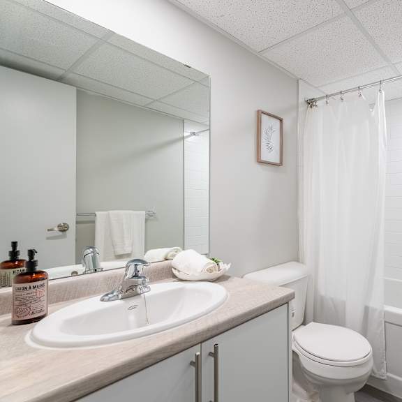 a white bathroom with a sink, toilet, and bathtub  at platts crossing, london, on, n6h 4p4
