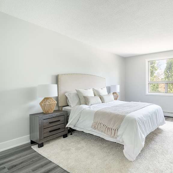 a bedroom with a large bed and a window  at platts crossing, london, on, n6h 4p4