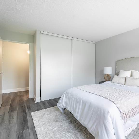 a bedroom with a large bed and a nightstand with a lamp  at platts crossing, london, on, n6h 4p4