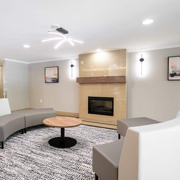 a modern living room with a fireplace and grey couches  at platts crossing, london, on, n6h 4p4