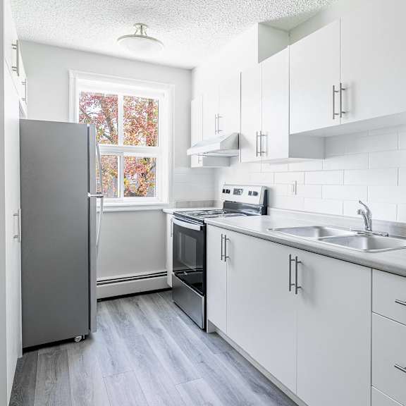 oakland kitchen with white cabinets and a grey fridge.