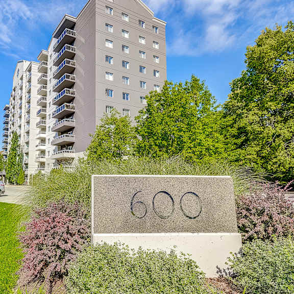 a large stone sign with the number 60 on it in front of an apartment building