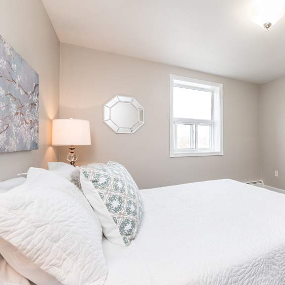 a bedroom with a large white bed and a window