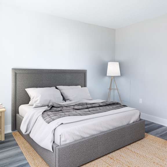 a bedroom with a large bed and a lamp on a side table.