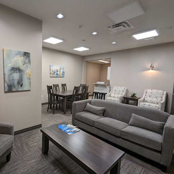 resident lounge white countertops and a wooden island with three red chairs