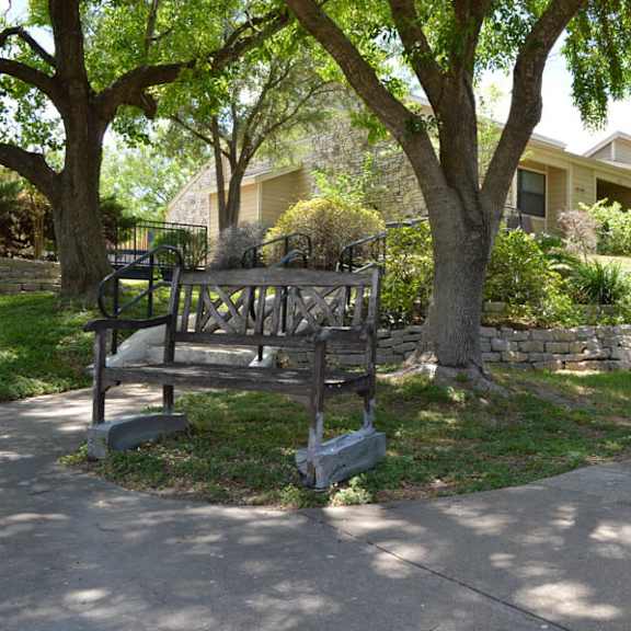 a playground with a swing set is located in front of a house.