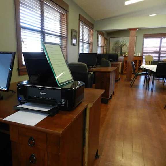 a room with a printer on a desk and a monitor.