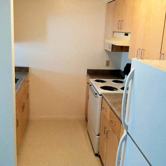 a kitchen with a white refrigerator, a white dishwasher, and a white stove.