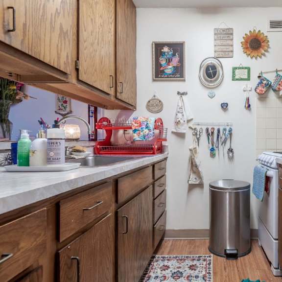 a kitchen with a refrigerator covered in magnets and notes.
