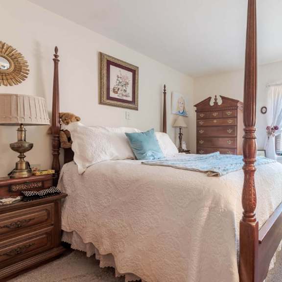 a bedroom with a four poster bed and a dresser.