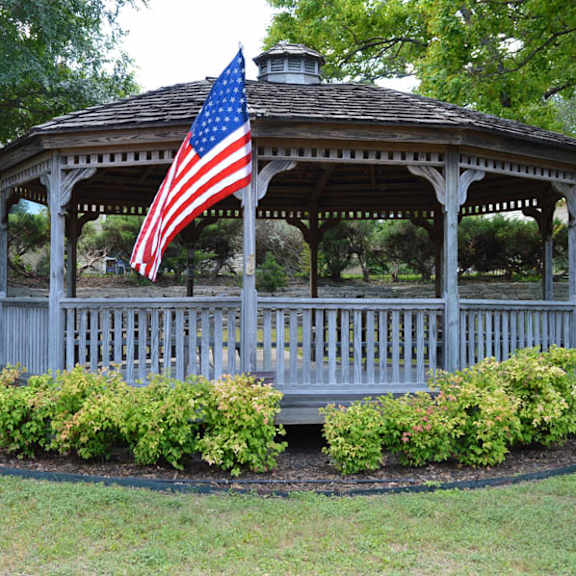 a gazebo with an american flag hanging from the roof.