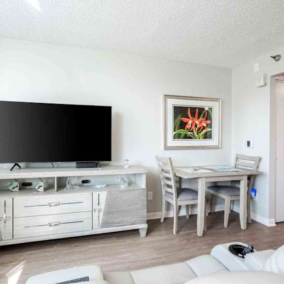 a living room with a television, chair, and table.