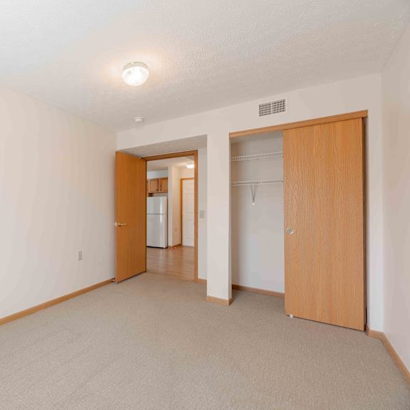 a room with a carpeted floor and two wooden doors.