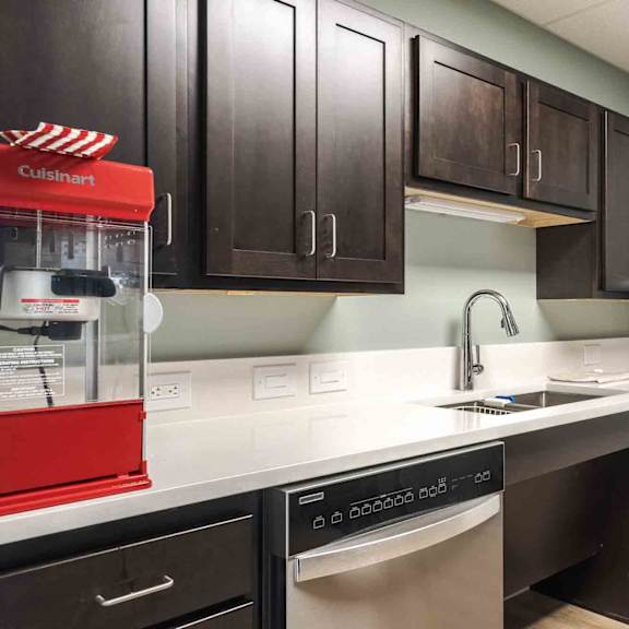 a kitchen with black cabinets and a red cuisinart appliance.