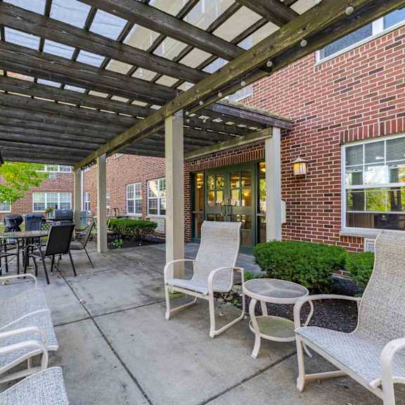 a patio with a table and chairs under a roof.