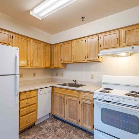 a kitchen with wooden cabinets and a white refrigerator.