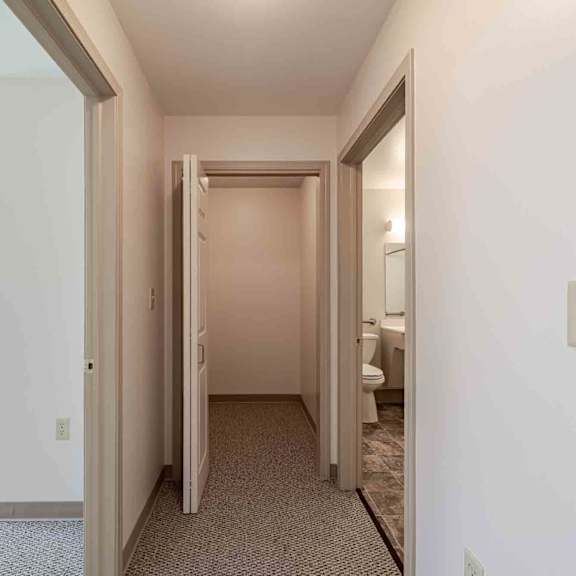 a hallway with a carpeted floor and white walls.