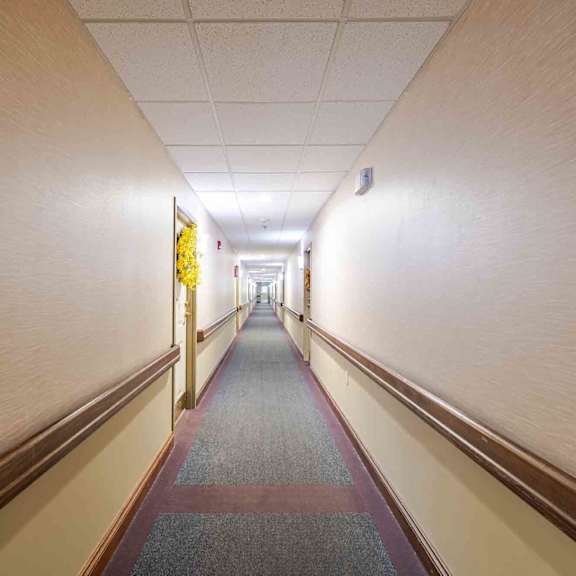 a long hallway with a carpeted floor and walls on either side.