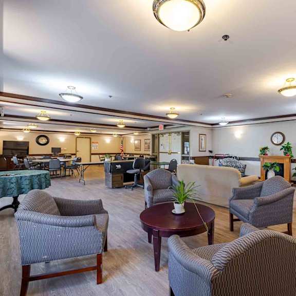 a living room with grey chairs and a green tablecloth.