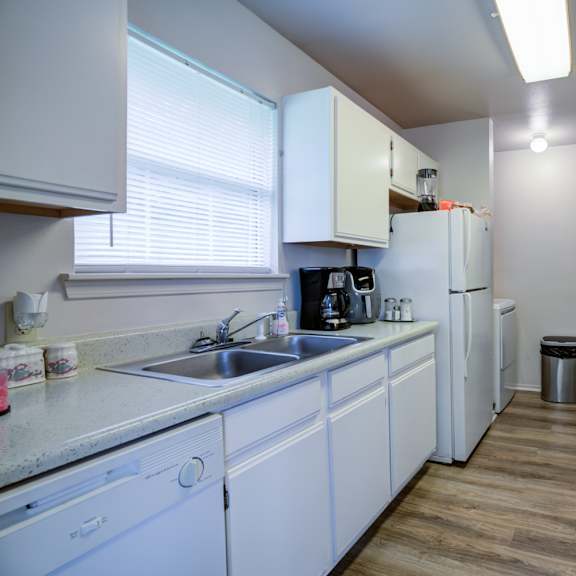 a kitchen with white cabinets and appliances.