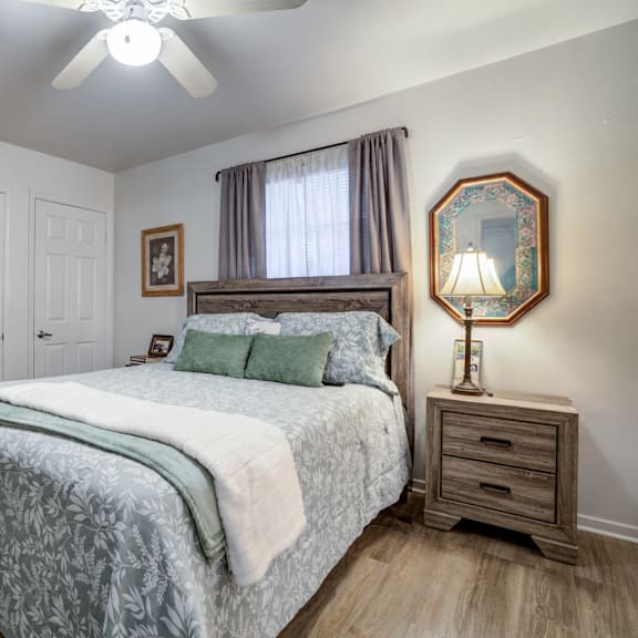a bedroom with a bed, dresser, and mirror.