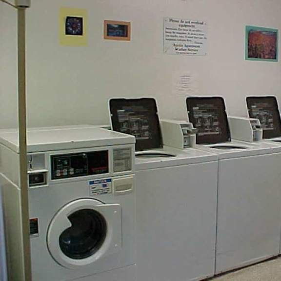 a row of washing machines are lined up in a laundromat.