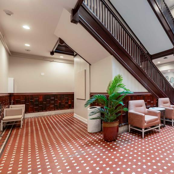 a living room with a staircase and a plant.