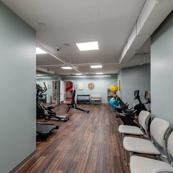 a gym with a row of chairs and exercise equipment.