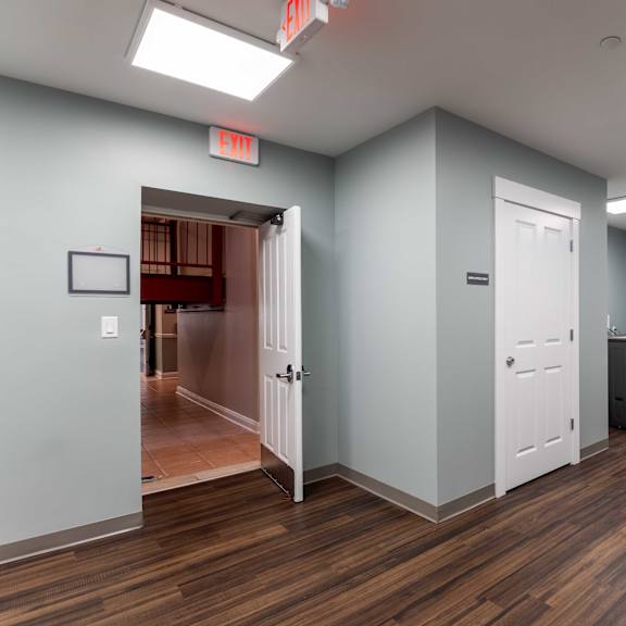 a room with wood flooring and white doors.