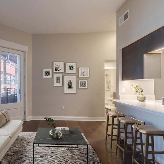 a living room with a white couch, a coffee table, and a bar area.